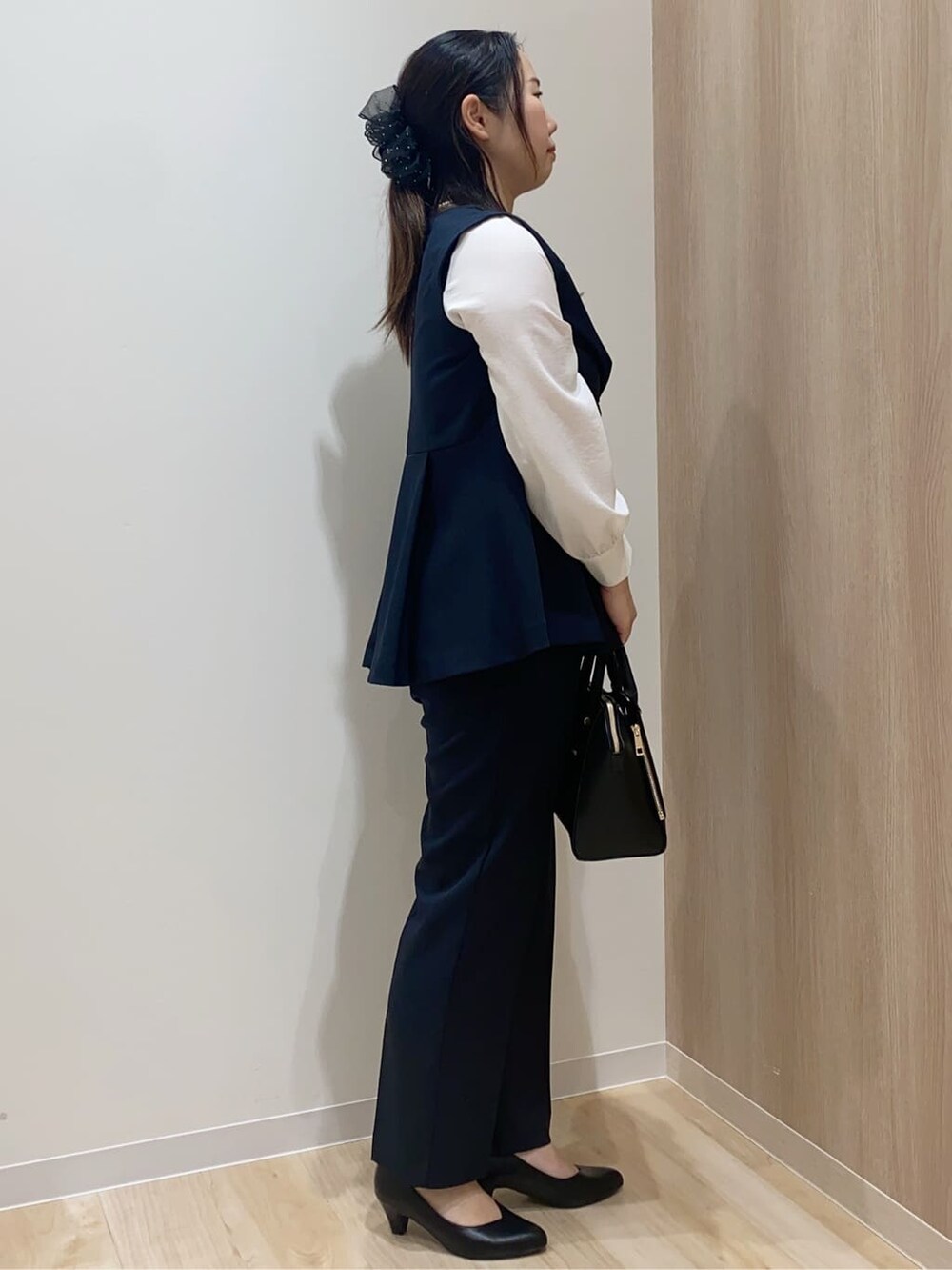 ピンク系のニット/セーター、ブラック系のパンプス、ブラック系のトートバッグを着用したレディースの冬コーディネートの2枚目の写真