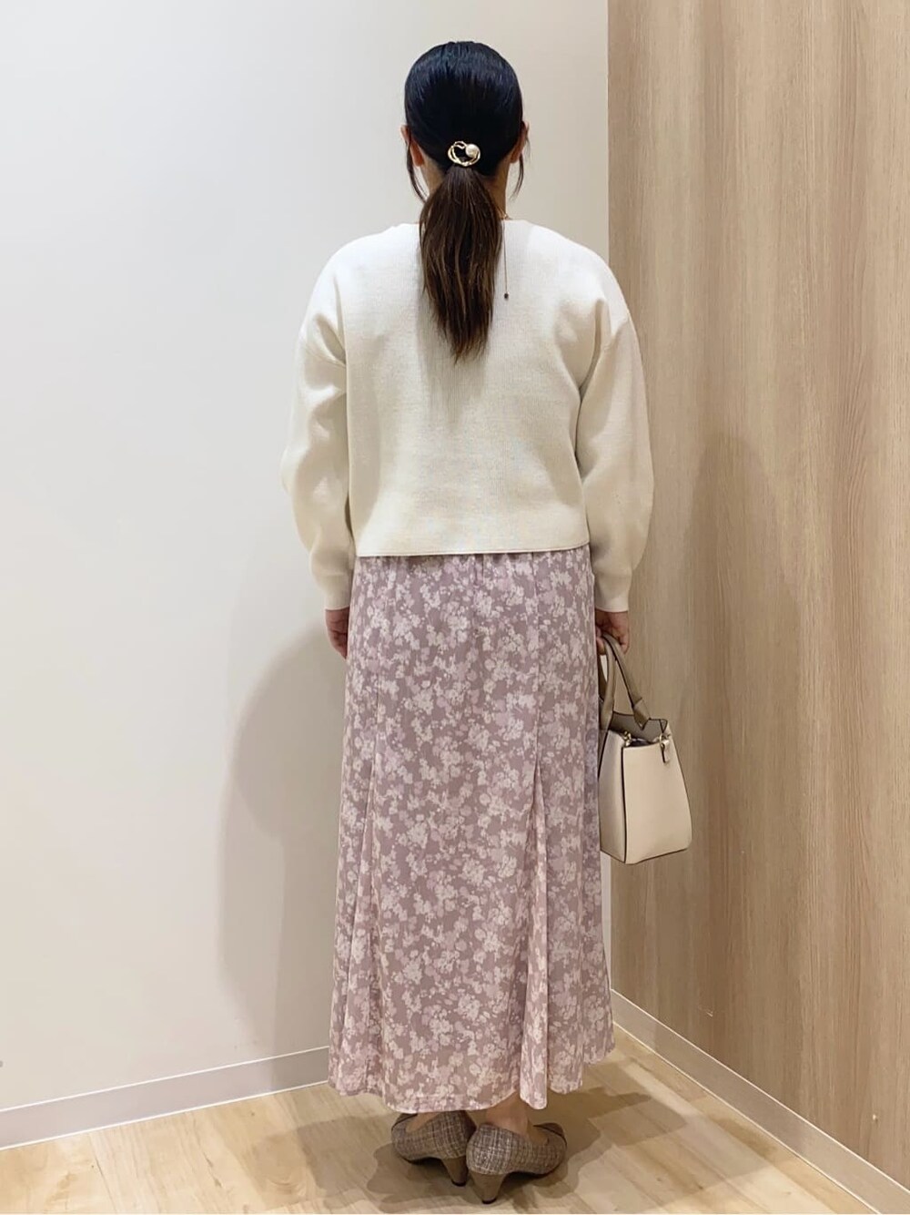 ブラウン系のパンプス、ベージュ系のトートバッグ、ホワイト系のニット/セーターを着用したレディースの冬コーディネートの4枚目の写真