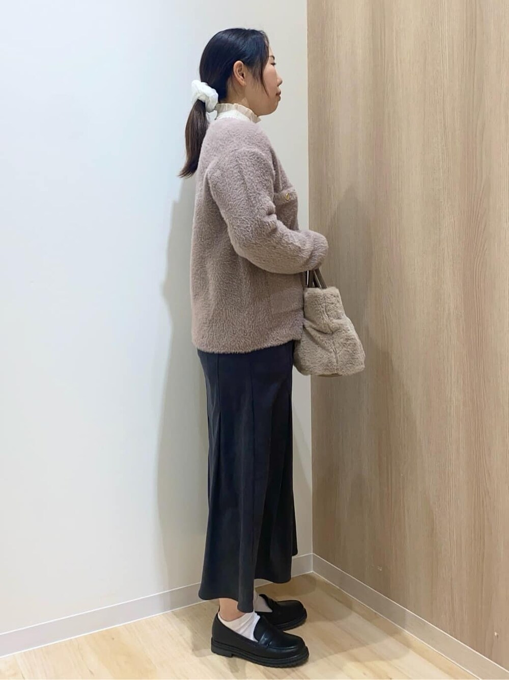 ベージュ系のカーディガン/ボレロ、ホワイト系のニット/セーター、グレー系のスカートを着用したレディースの秋コーディネートの2枚目の写真