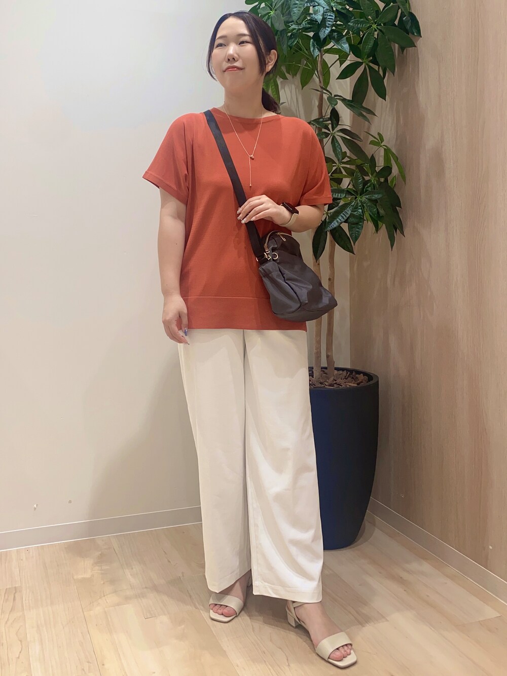 レッド系のニット/セーター、ホワイト系のその他パンツ、グレー系のショルダーバッグを着用したレディースの夏コーディネートの2枚目の写真