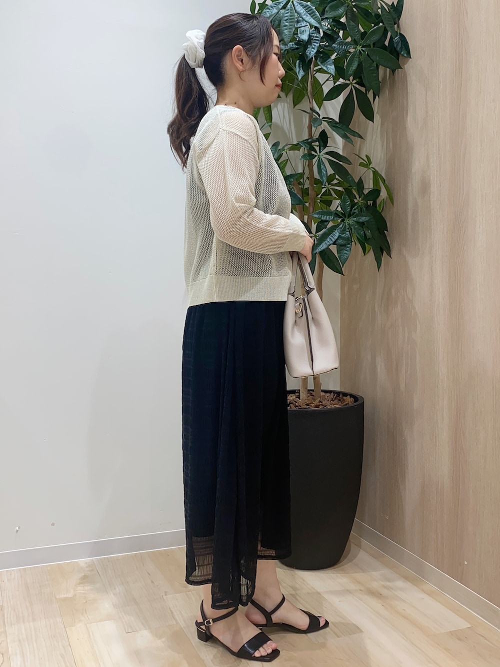 ホワイト系のカーディガン/ボレロ、ブラック系のワンピース、ベージュ系のトートバッグを着用したレディースの夏コーディネートの3枚目の写真