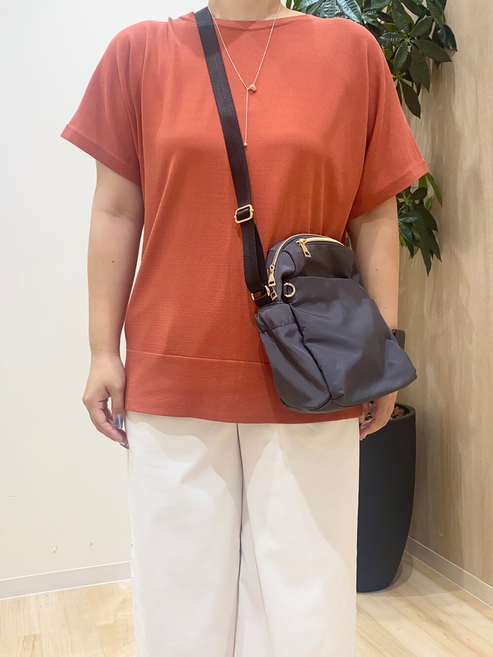 レッド系のニット/セーター、ホワイト系のその他パンツ、グレー系のショルダーバッグを着用したレディースの夏コーディネートの5枚目の写真