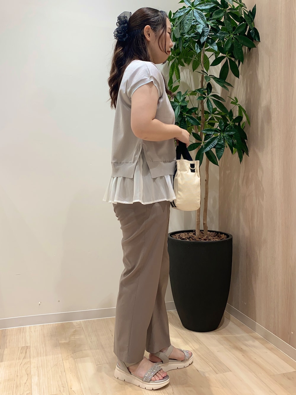 グレー系のニット/セーター、ベージュ系のその他パンツ、ブラック系のトートバッグを着用したレディースの夏コーディネートの3枚目の写真