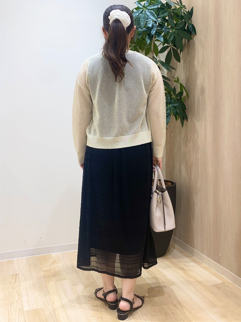 ホワイト系のカーディガン/ボレロ、ブラック系のワンピース、ベージュ系のトートバッグを着用したレディースの夏コーディネートの4枚目の写真