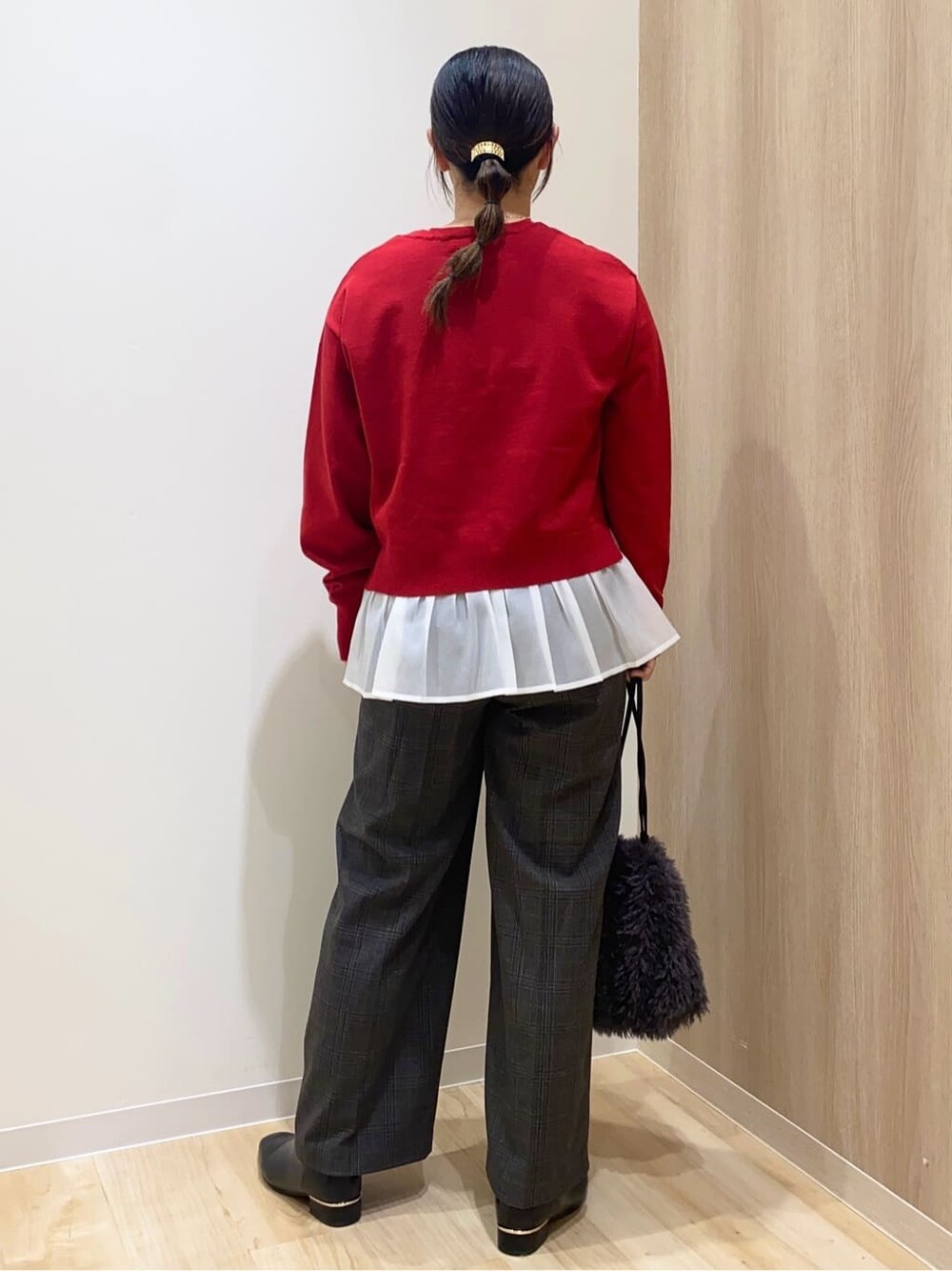 レッド系のニット/セーター、ブラック系のその他パンツ、グレー系のショルダーバッグを着用したレディースの冬コーディネートの3枚目の写真
