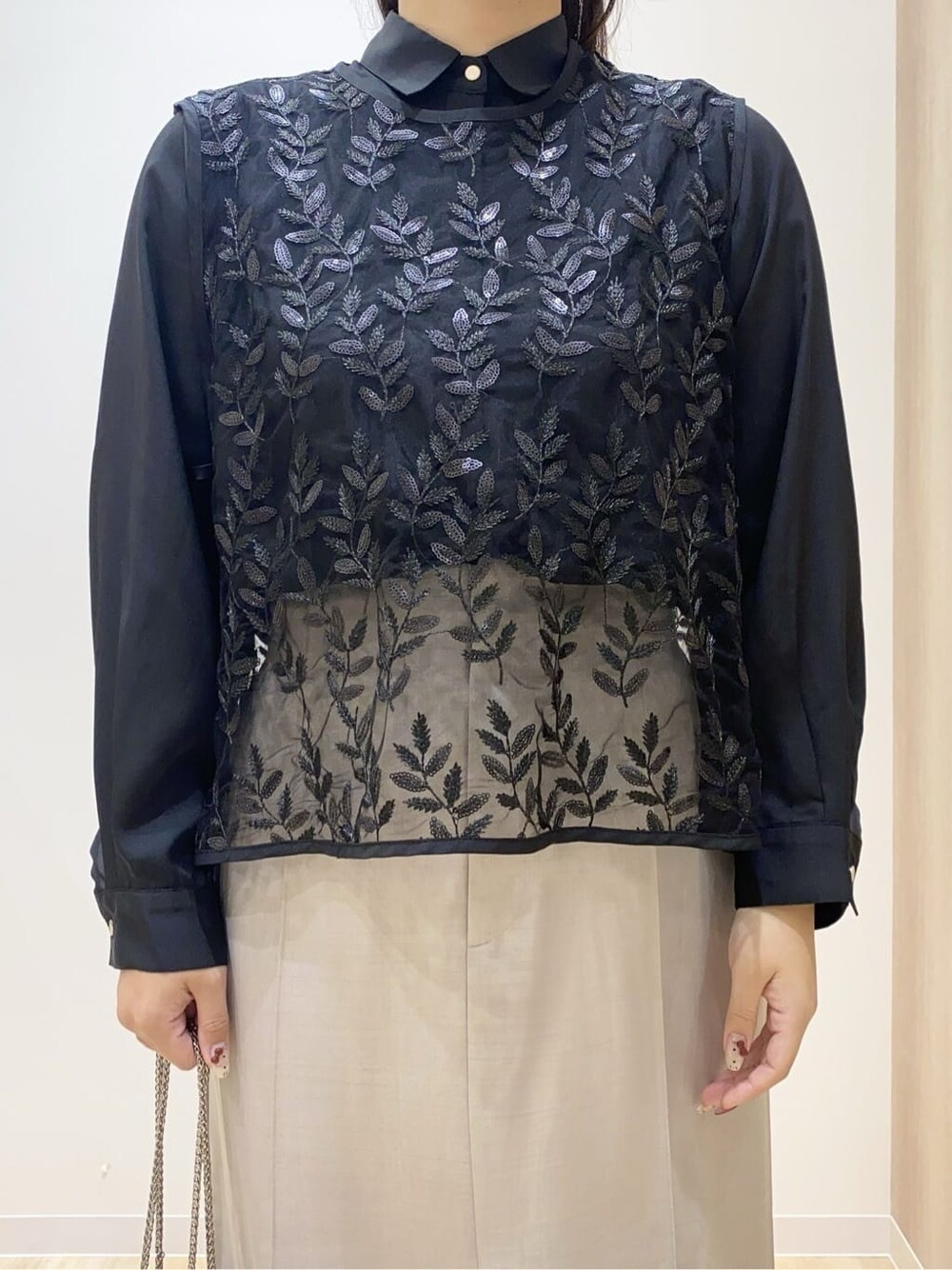 ブラック系のシャツ/ブラウス、ベージュ系のスカート、ブラック系のショルダーバッグを着用したレディースの秋コーディネートの5枚目の写真