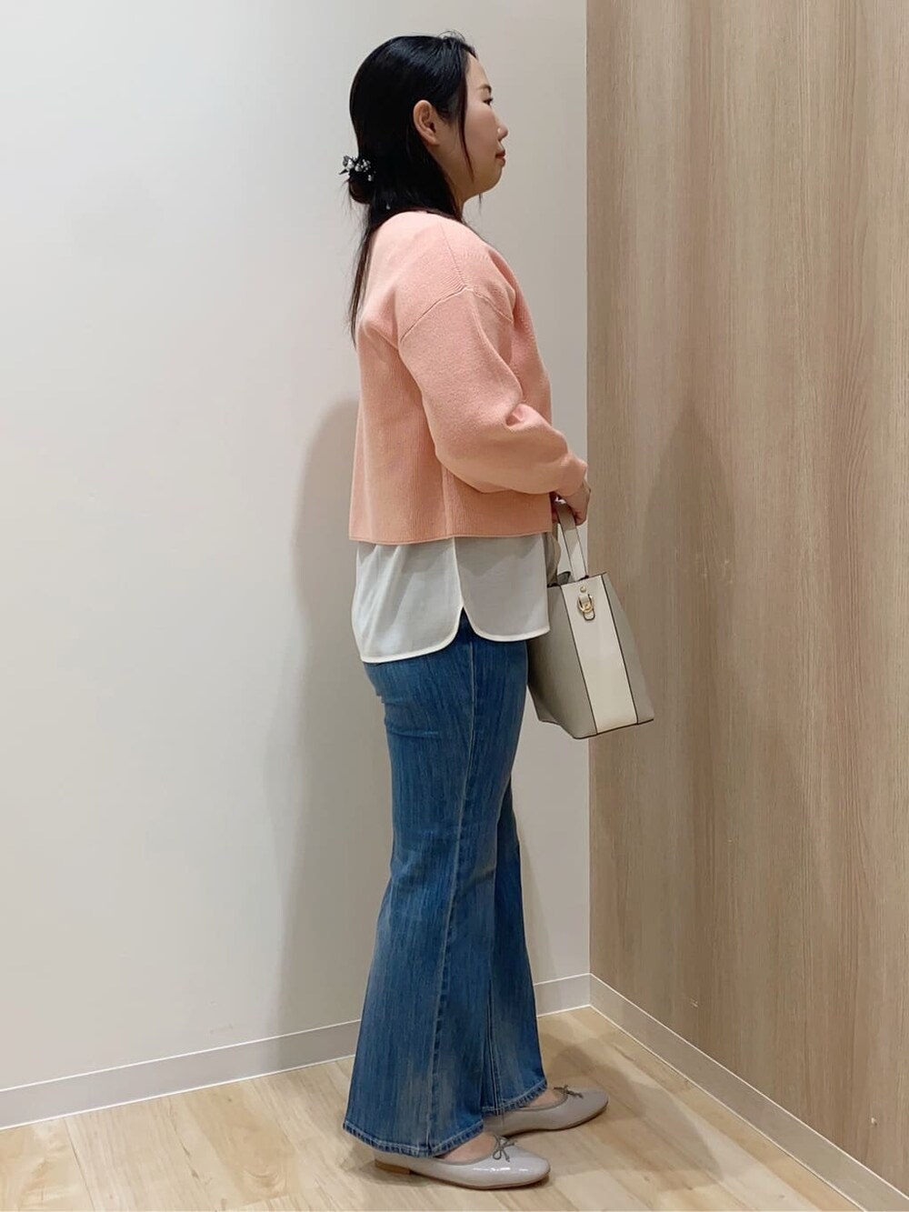 ピンク系のニット/セーター、ホワイト系のTシャツ/カットソー、ブルー系のデニムパンツを着用したレディースの冬コーディネートの2枚目の写真