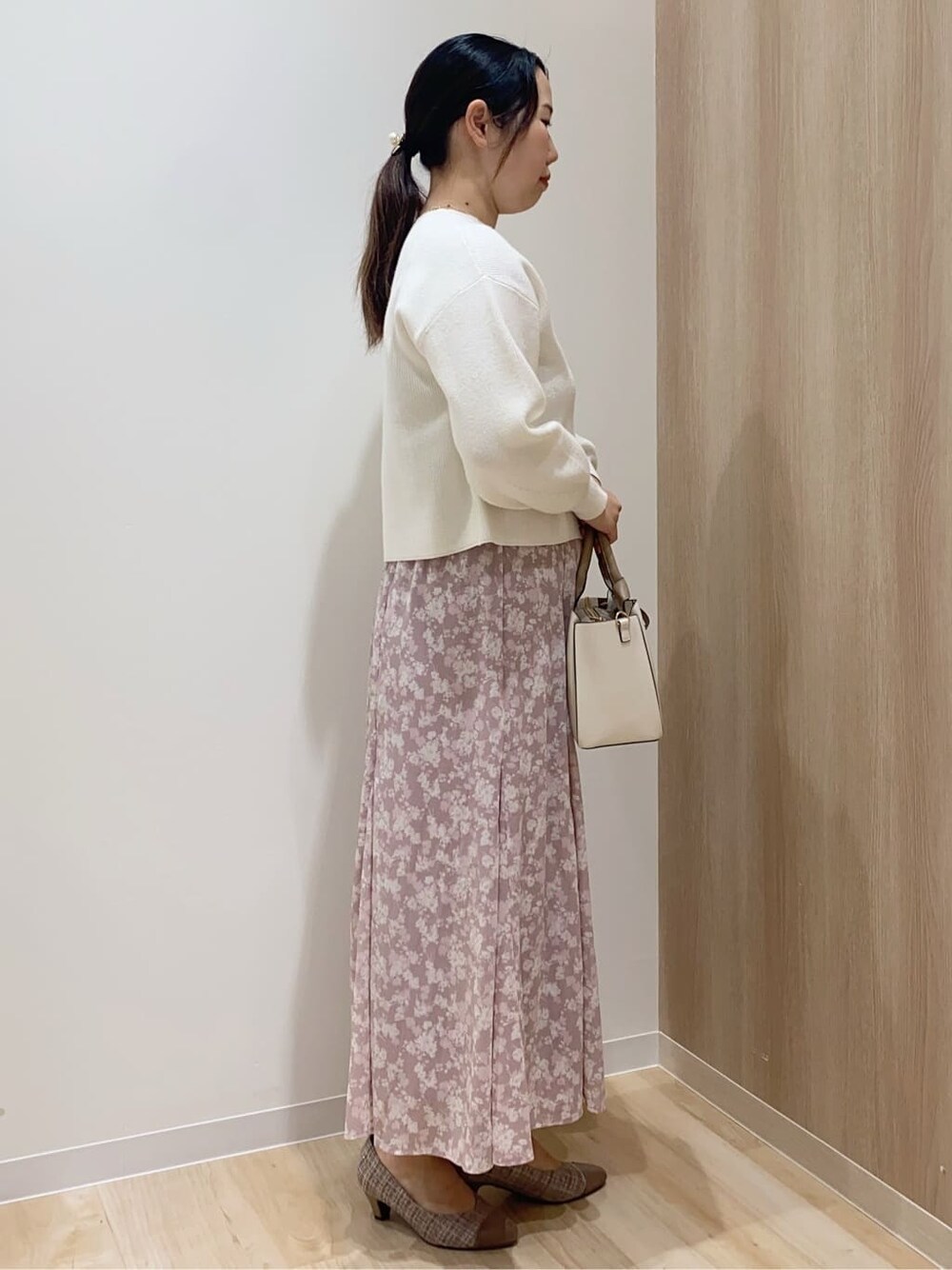 ブラウン系のパンプス、ベージュ系のトートバッグ、ホワイト系のニット/セーターを着用したレディースの冬コーディネートの3枚目の写真