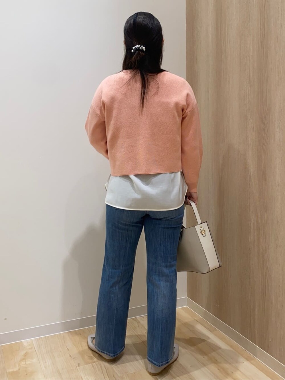 ピンク系のニット/セーター、ホワイト系のTシャツ/カットソー、ブルー系のデニムパンツを着用したレディースの冬コーディネートの3枚目の写真