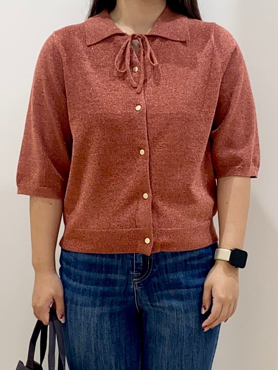 レッド系のニット/セーター、ブルー系のデニムパンツ、グレー系のトートバッグを着用したレディースの秋コーディネートの4枚目の写真