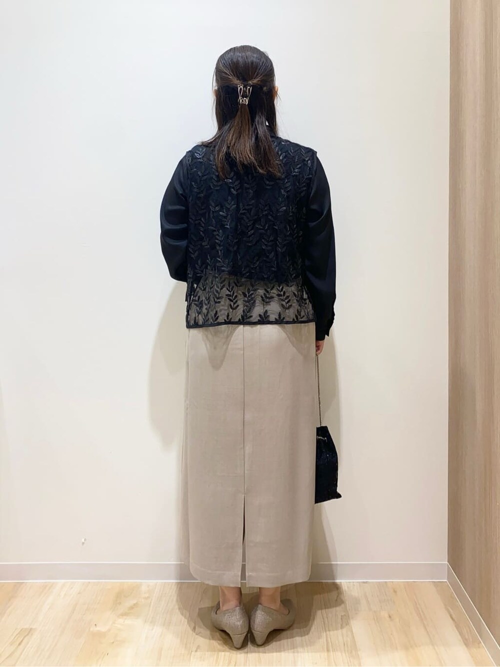 ブラック系のシャツ/ブラウス、ベージュ系のスカート、ブラック系のショルダーバッグを着用したレディースの秋コーディネートの4枚目の写真