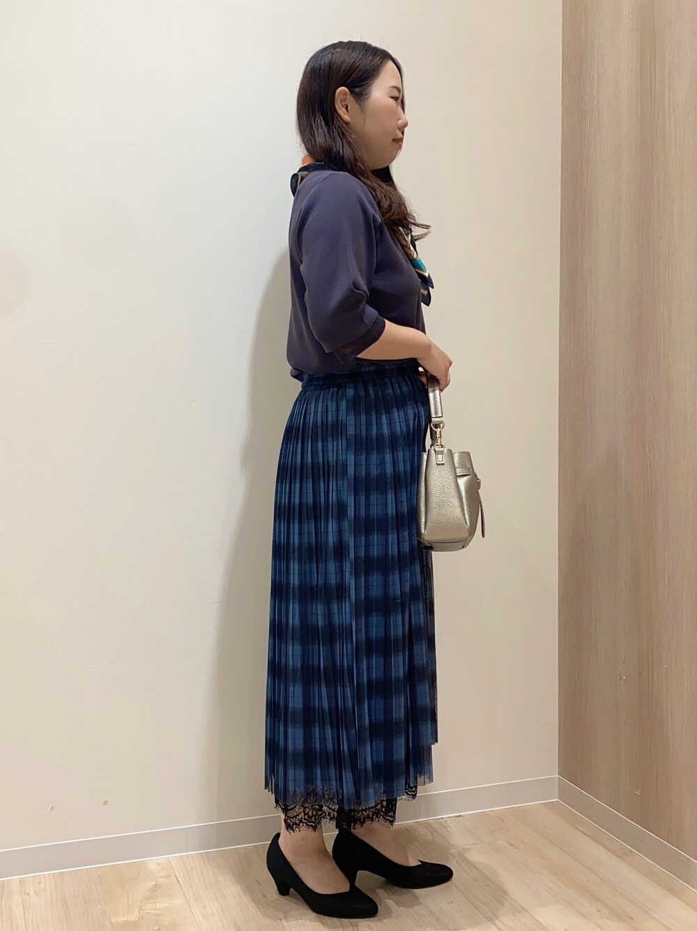 グレー系のニット/セーター、ブルー系のスカート、シルバー系のショルダーバッグを着用したレディースの秋コーディネートの3枚目の写真