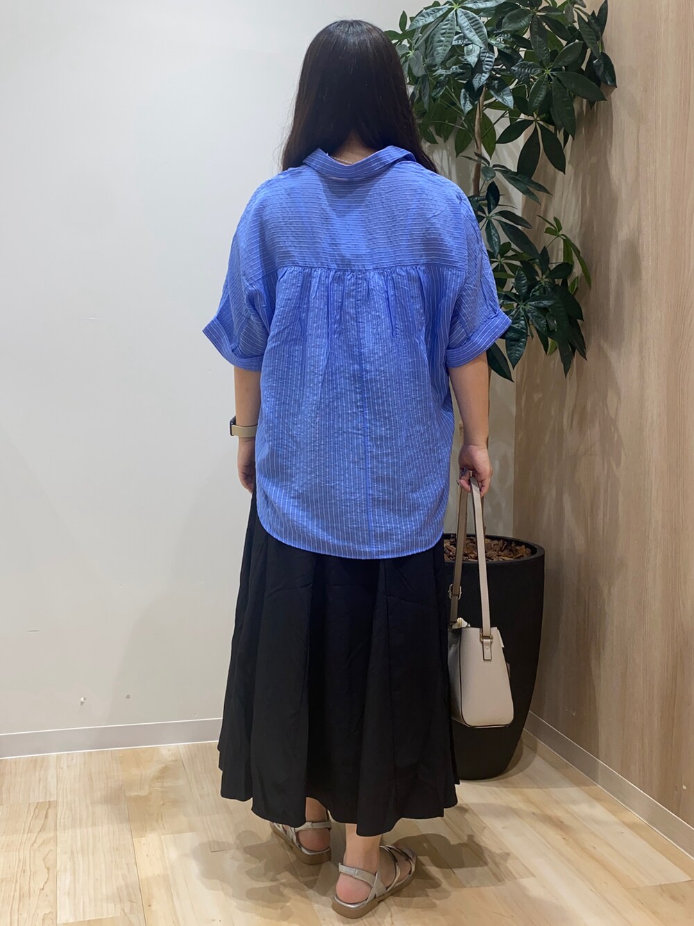 ブルー系のシャツ/ブラウス、ブラック系のスカート、グレー系のショルダーバッグを着用したレディースの夏コーディネートの4枚目の写真