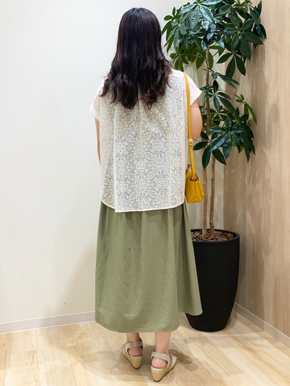 グリーン系のワンピース、ホワイト系のシャツ/ブラウス、ゴールド系のネックレスを着用したレディースの夏コーディネートの4枚目の写真