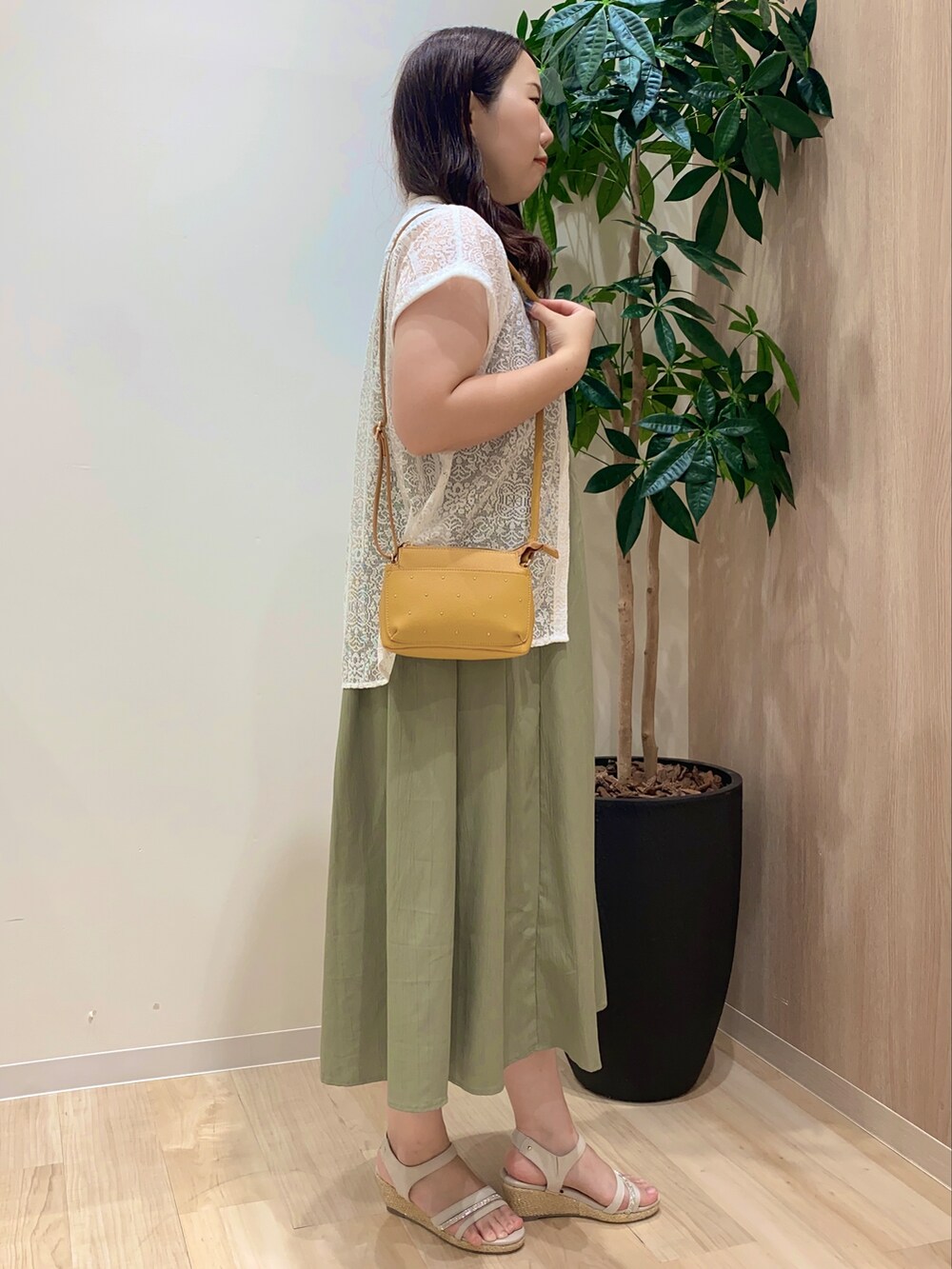 グリーン系のワンピース、ホワイト系のシャツ/ブラウス、ゴールド系のネックレスを着用したレディースの夏コーディネートの3枚目の写真