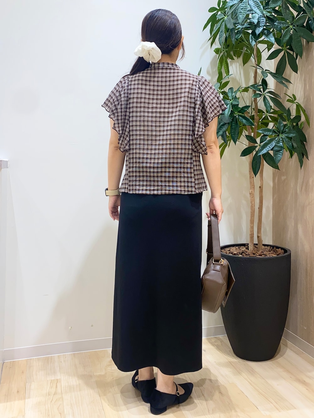 ブラウン系のシャツ/ブラウス、ブラック系のスカート、ブラウン系のショルダーバッグを着用したレディースの夏コーディネートの4枚目の写真