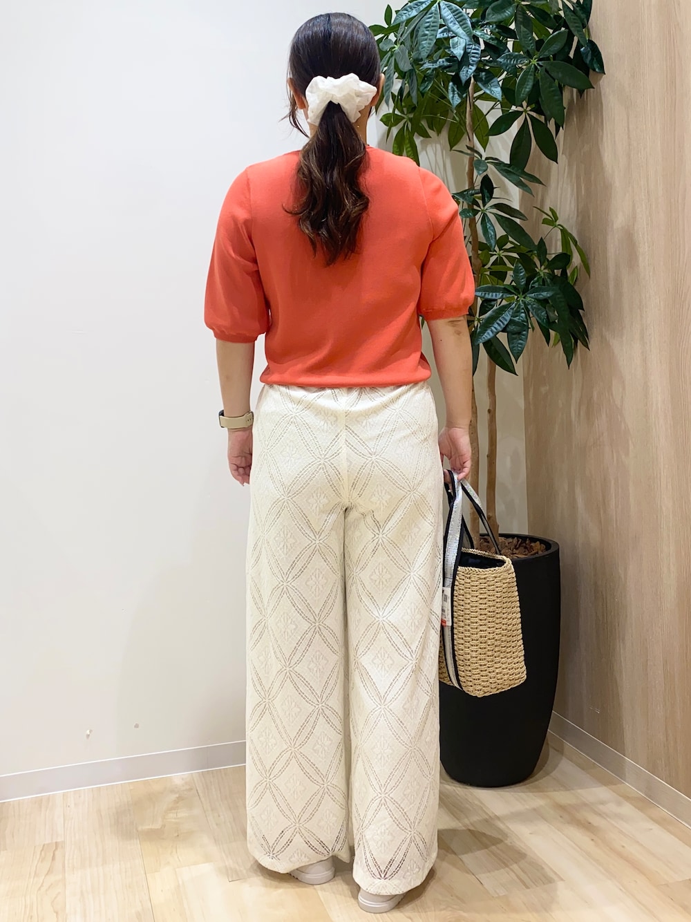レッド系のニット/セーター、ホワイト系のその他パンツ、ベージュ系のトートバッグを着用したレディースの夏コーディネートの4枚目の写真