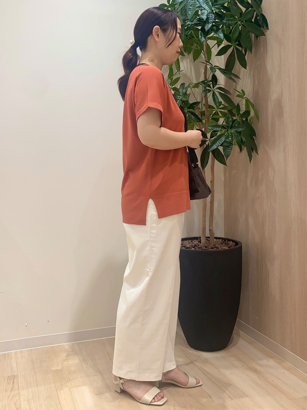 レッド系のニット/セーター、ホワイト系のその他パンツ、グレー系のショルダーバッグを着用したレディースの夏コーディネートの3枚目の写真