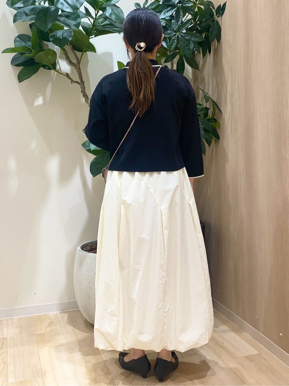 ブラック系のカーディガン/ボレロ、ホワイト系のスカート、シルバー系のショルダーバッグを着用したレディースの春コーディネートの3枚目の写真
