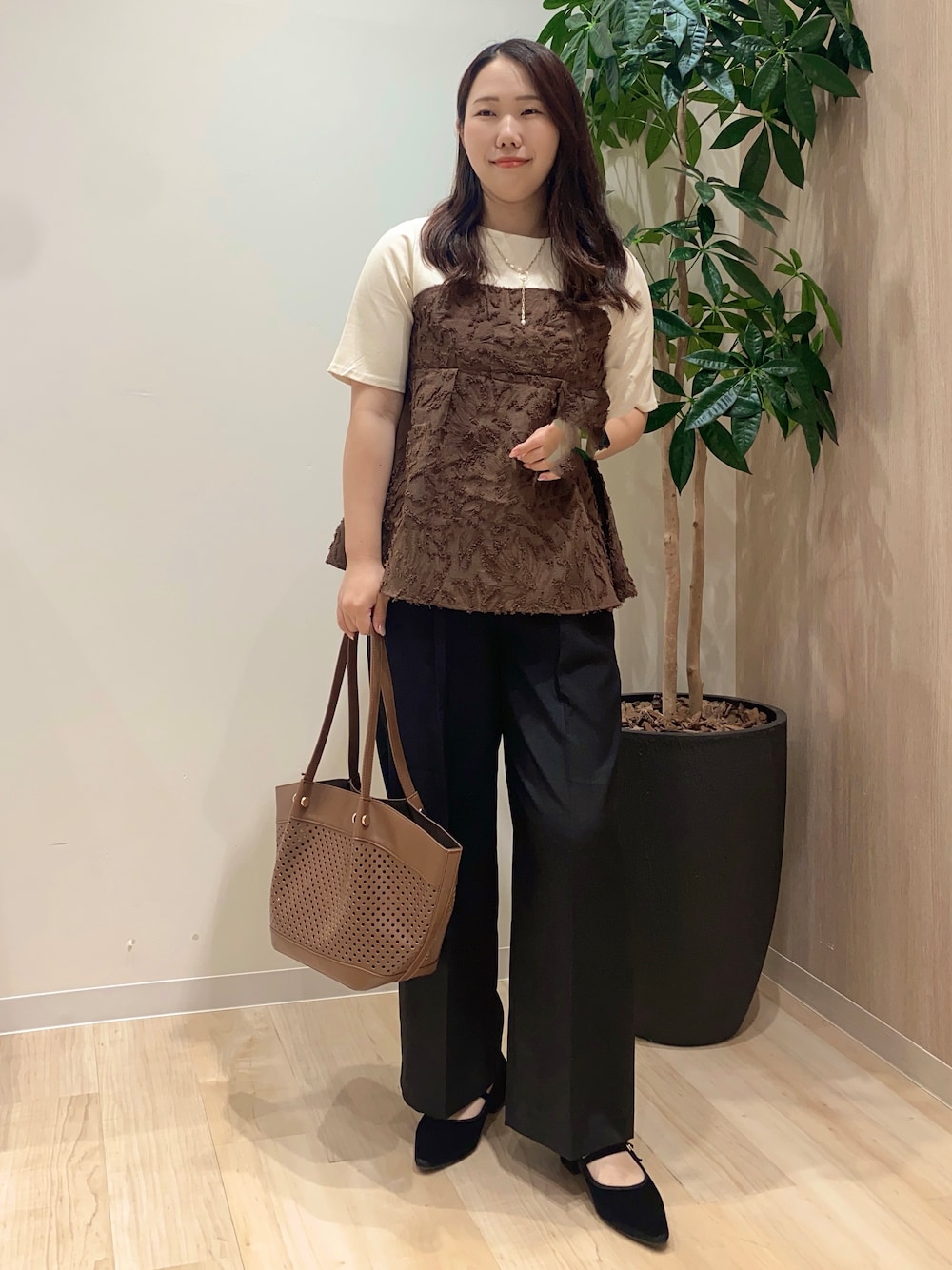 ブラウン系のTシャツ/カットソー、ブラック系のその他パンツ、ブラウン系のトートバッグを着用したレディースの夏コーディネートの2枚目の写真
