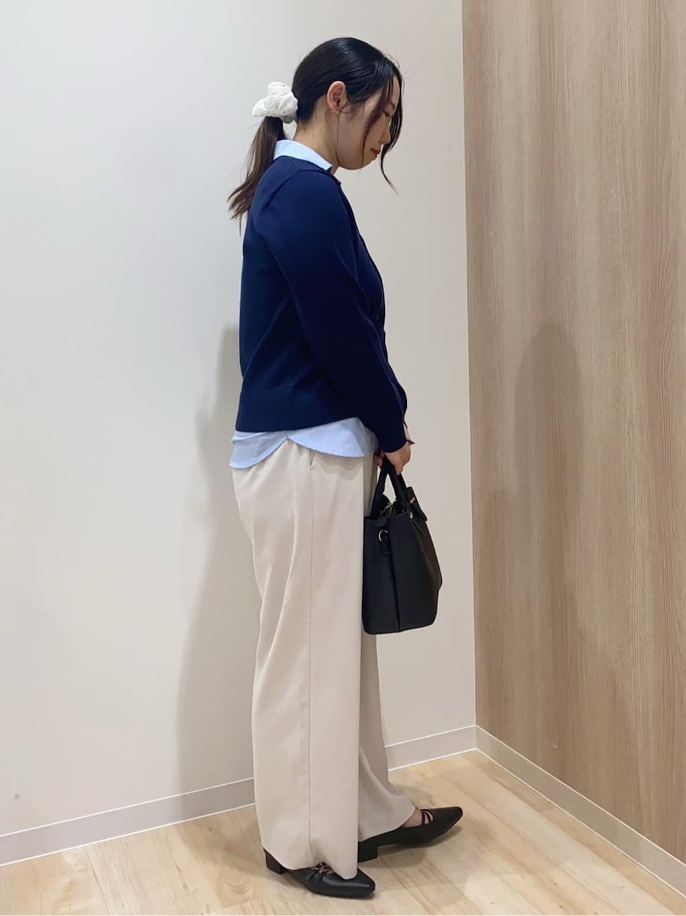 ブラック系のトートバッグ、ベージュ系のその他パンツ、ホワイト系のポロシャツを着用したレディースの冬コーディネートの2枚目の写真