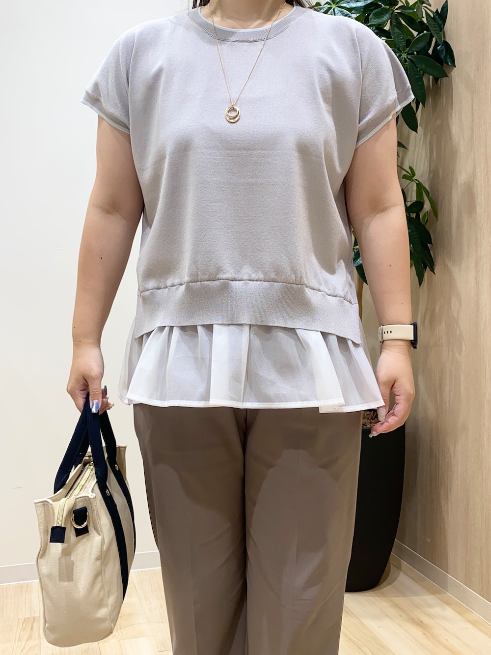 グレー系のニット/セーター、ベージュ系のその他パンツ、ブラック系のトートバッグを着用したレディースの夏コーディネートの5枚目の写真