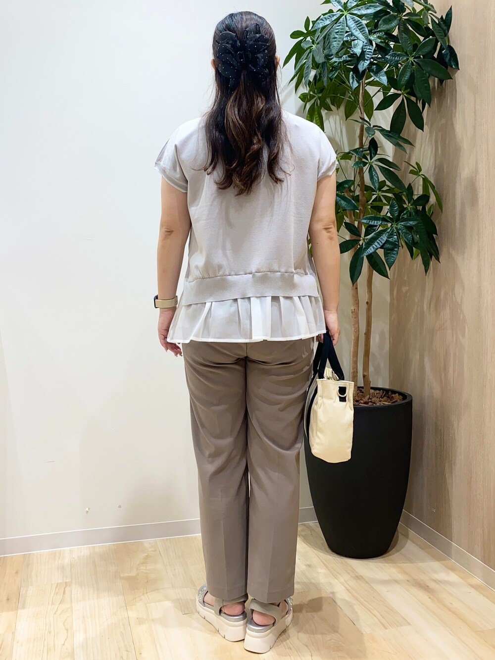 グレー系のニット/セーター、ベージュ系のその他パンツ、ブラック系のトートバッグを着用したレディースの夏コーディネートの4枚目の写真