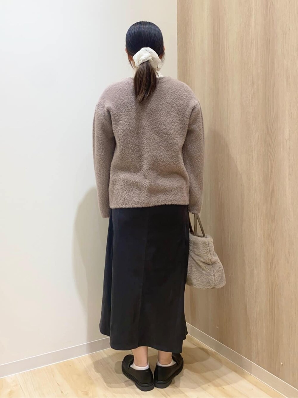 ベージュ系のカーディガン/ボレロ、ホワイト系のニット/セーター、グレー系のスカートを着用したレディースの秋コーディネートの3枚目の写真
