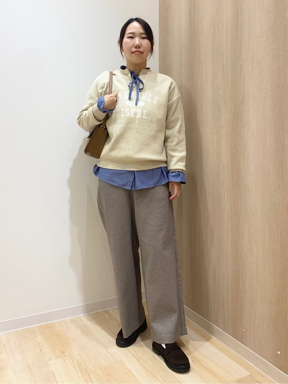 ホワイト系のニット/セーター、ブルー系のシャツ/ブラウス、ベージュ系のその他パンツを着用したレディースの秋コーディネートの2枚目の写真