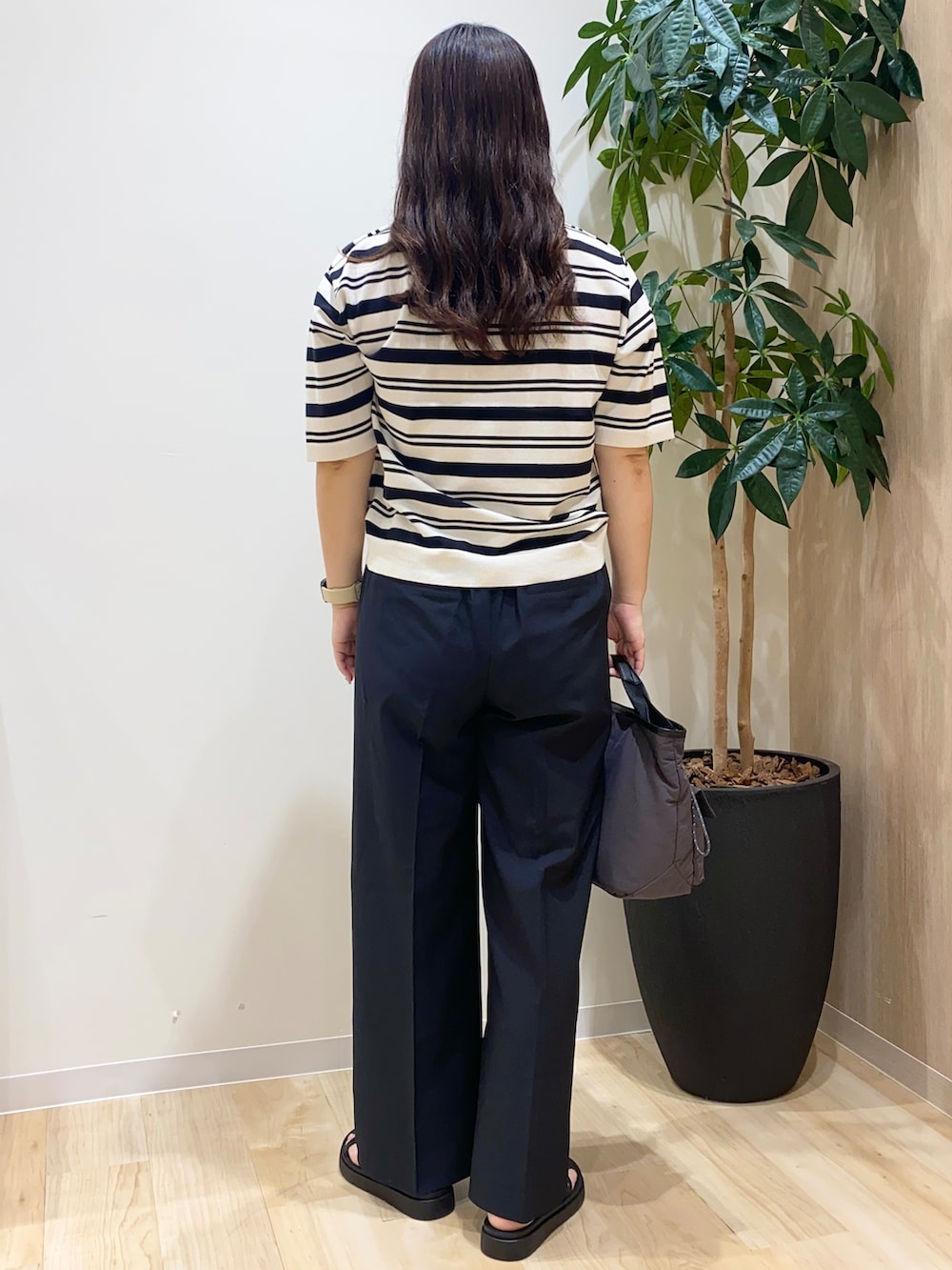 ホワイト系のニット/セーター、ブラック系のその他パンツ、グレー系のショルダーバッグを着用したレディースの夏コーディネートの4枚目の写真