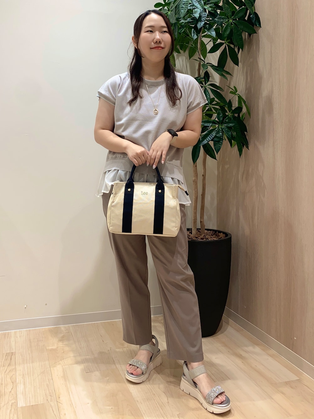 グレー系のニット/セーター、ベージュ系のその他パンツ、ブラック系のトートバッグを着用したレディースの夏コーディネートの2枚目の写真