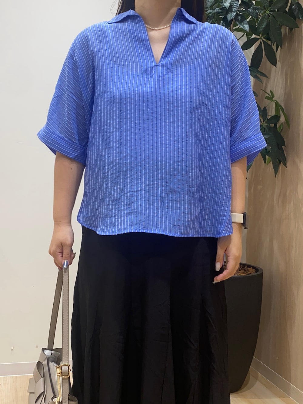 ブルー系のシャツ/ブラウス、ブラック系のスカート、グレー系のショルダーバッグを着用したレディースの夏コーディネートの5枚目の写真