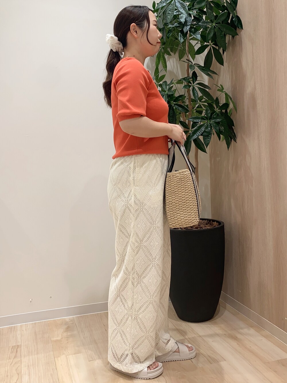 レッド系のニット/セーター、ホワイト系のその他パンツ、ベージュ系のトートバッグを着用したレディースの夏コーディネートの3枚目の写真