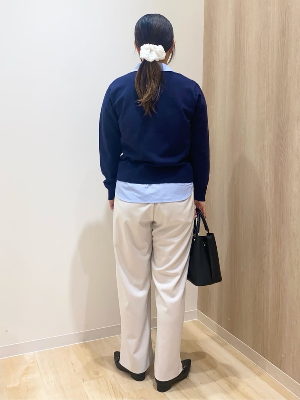 ブラック系のトートバッグ、ベージュ系のその他パンツ、ホワイト系のポロシャツを着用したレディースの冬コーディネートの3枚目の写真