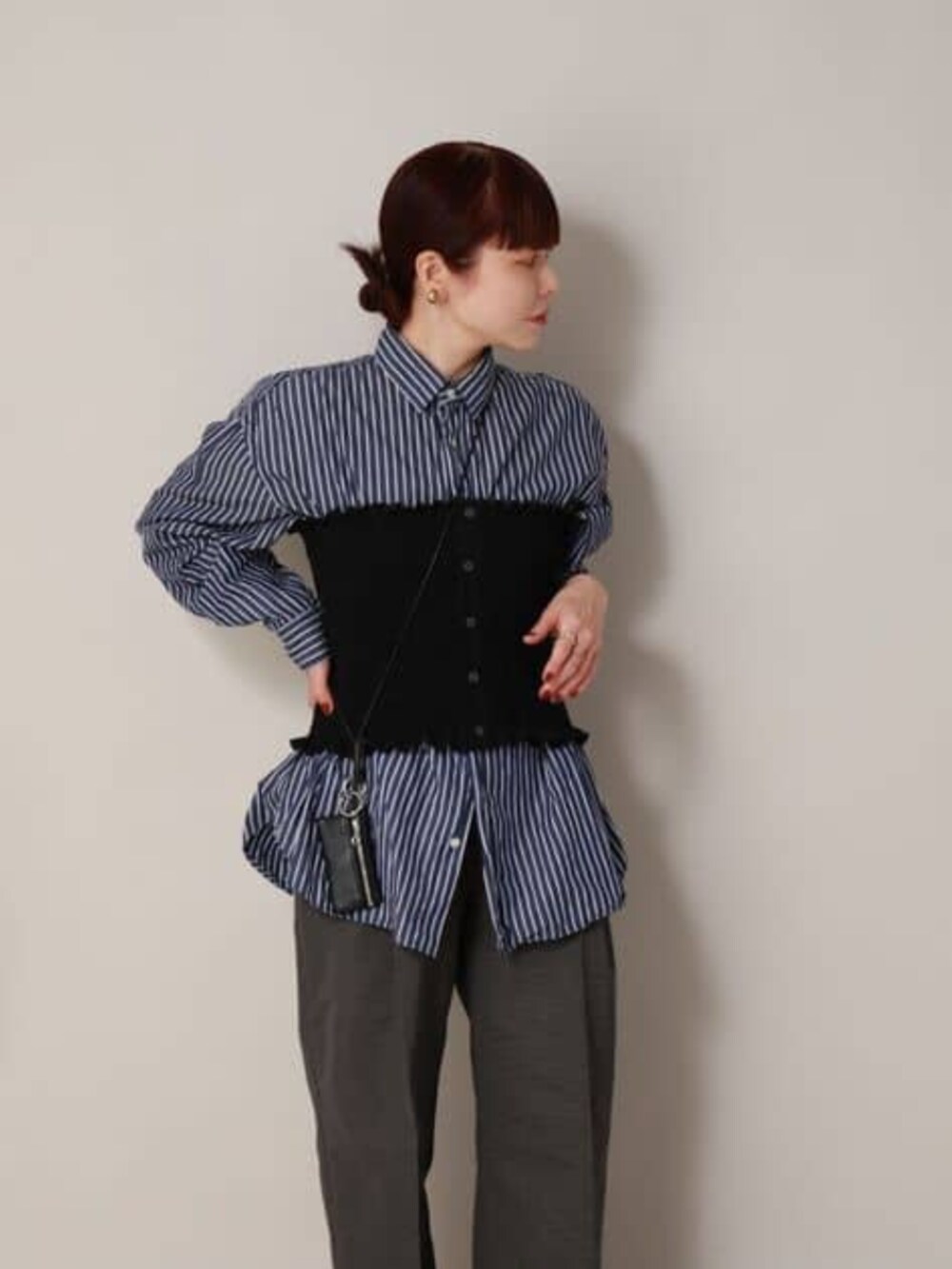 ブラック系のシャツ/ブラウス、グレー系のスラックスを着用したレディースの冬コーディネートの8枚目の写真