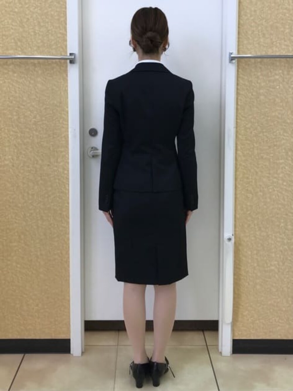 ブラック系のスーツジャケット、ブラック系のスーツスカートを着用したレディースの冬コーディネートの4枚目の写真