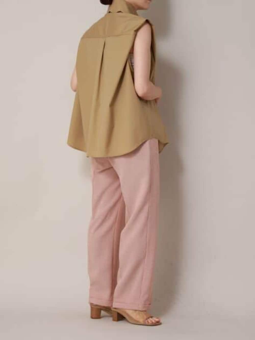 ベージュ系のシャツ/ブラウス、オレンジ系のスラックスを着用したレディースの冬コーディネートの3枚目の写真