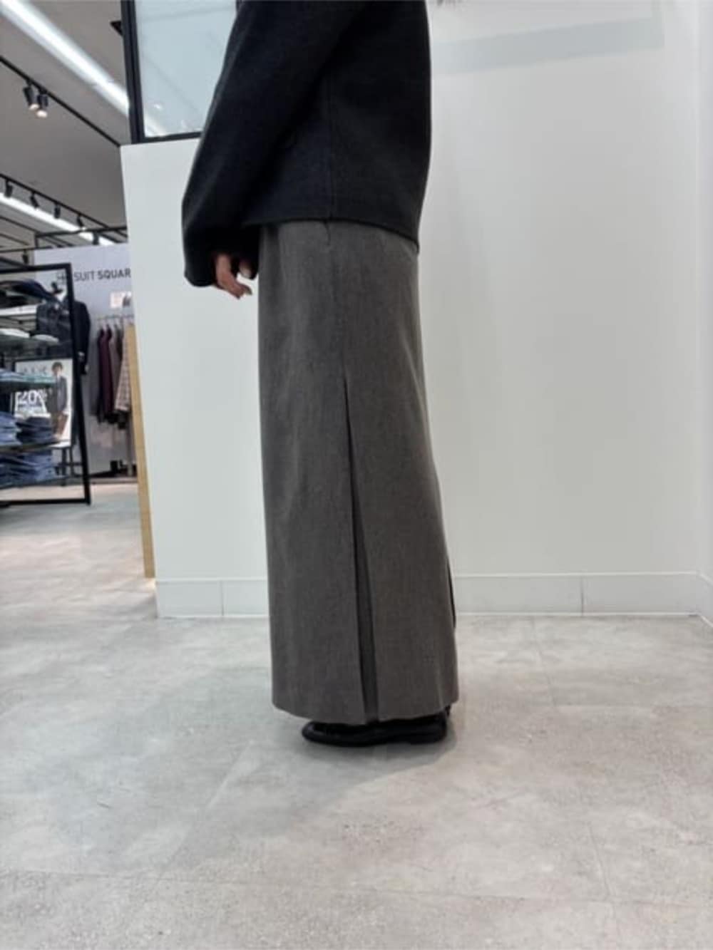 グレー系のノーカラージャケット、ベージュ系のショルダーバッグ、グレー系のスカートを着用したレディースの冬コーディネートの4枚目の写真