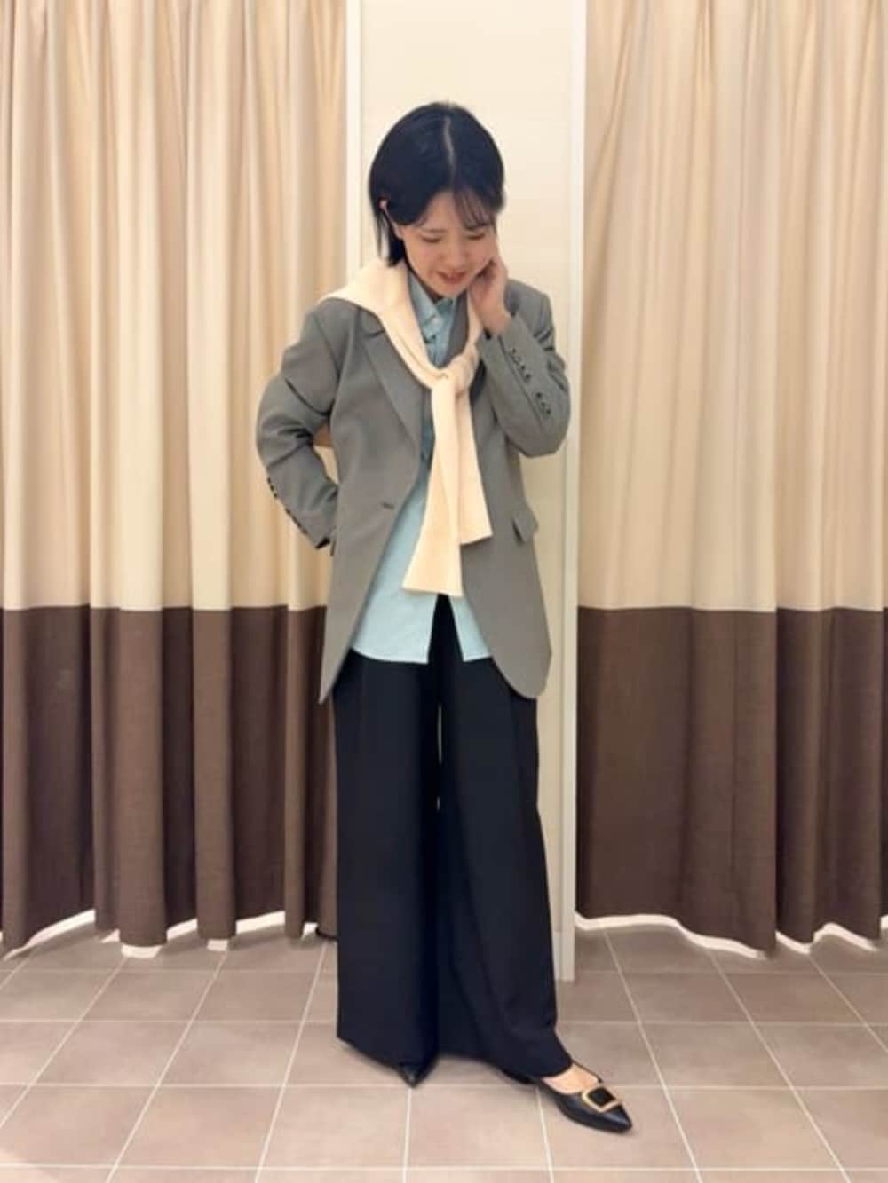 グレー系のテーラードジャケット、ブラック系のスラックス、グリーン系のシャツ/ブラウスを着用したレディースの冬コーディネートの2枚目の写真