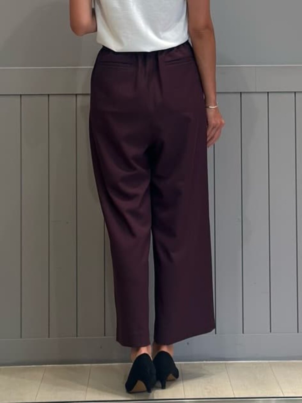 パープル系のスラックス、ホワイト系のテーラードジャケットを着用したレディースの冬コーディネートの7枚目の写真