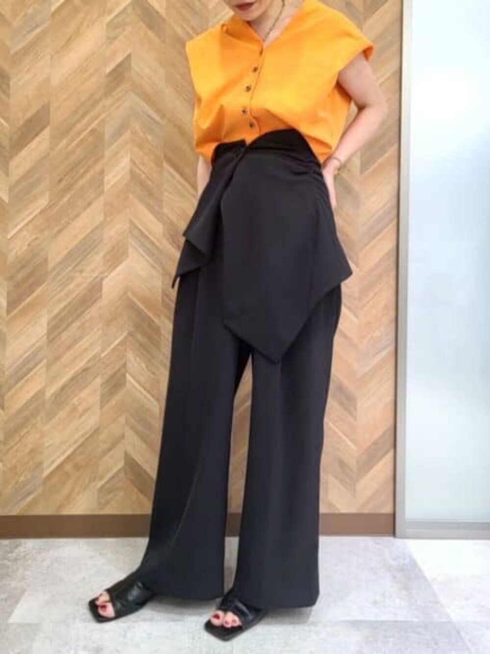 ブラック系のその他パンツ、オレンジ系のワンピースを着用したレディースの冬コーディネートの4枚目の写真