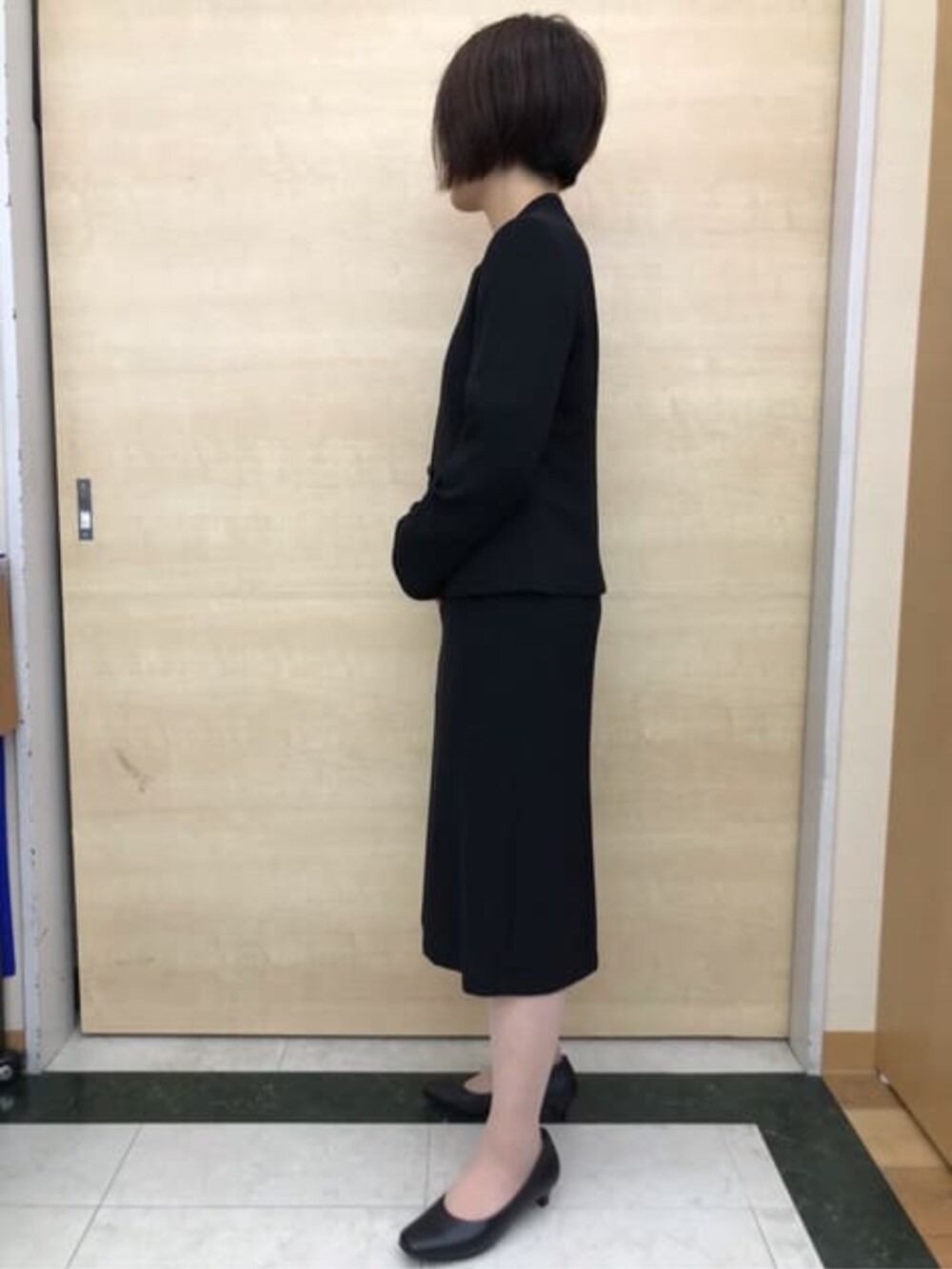 ブラック系のスーツセットを着用したレディースの冬コーディネートの3枚目の写真