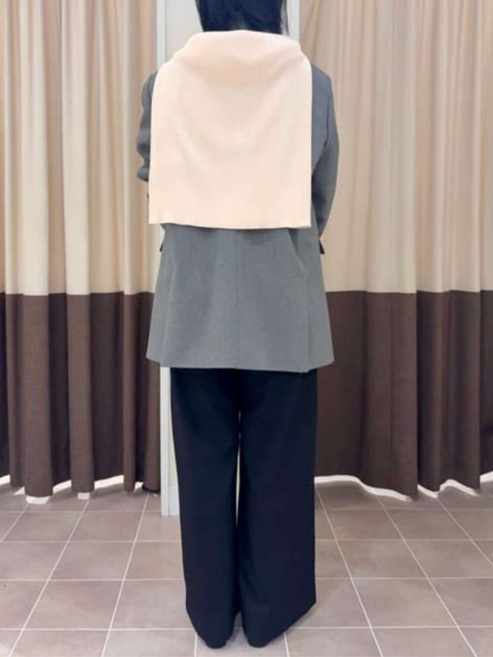 グレー系のテーラードジャケット、ブラック系のスラックス、グリーン系のシャツ/ブラウスを着用したレディースの冬コーディネートの6枚目の写真