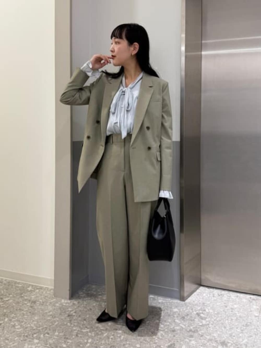 グリーン系のテーラードジャケット、グリーン系のスラックスを着用したレディースの春コーディネートの2枚目の写真