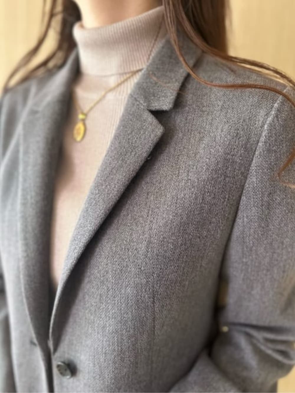 グレー系のスカート、グレー系のテーラードジャケット、ブラック系のショルダーバッグを着用したレディースの冬コーディネートの4枚目の写真