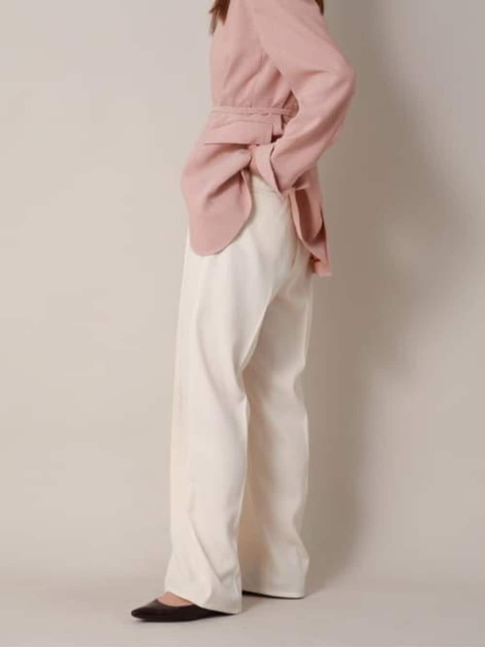 オレンジ系のテーラードジャケット、ホワイト系のスラックスを着用したレディースの冬コーディネートの4枚目の写真