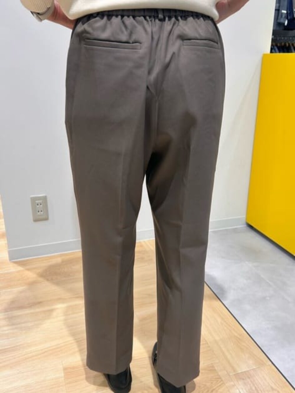 ベージュ系のニット/セーター、グリーン系のスラックスを着用したレディースの冬コーディネートの2枚目の写真