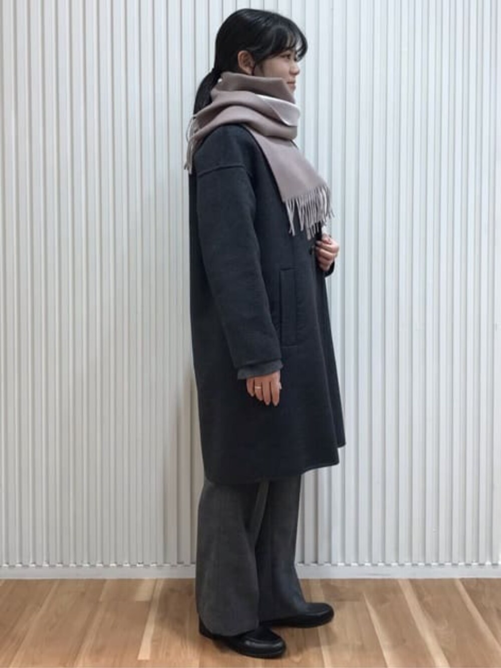 グレー系のピーコートを着用したレディースの冬コーディネートの2枚目の写真