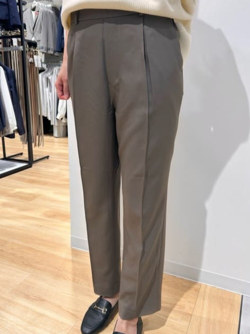 ベージュ系のニット/セーター、グリーン系のスラックスを着用したレディースの冬コーディネートの3枚目の写真