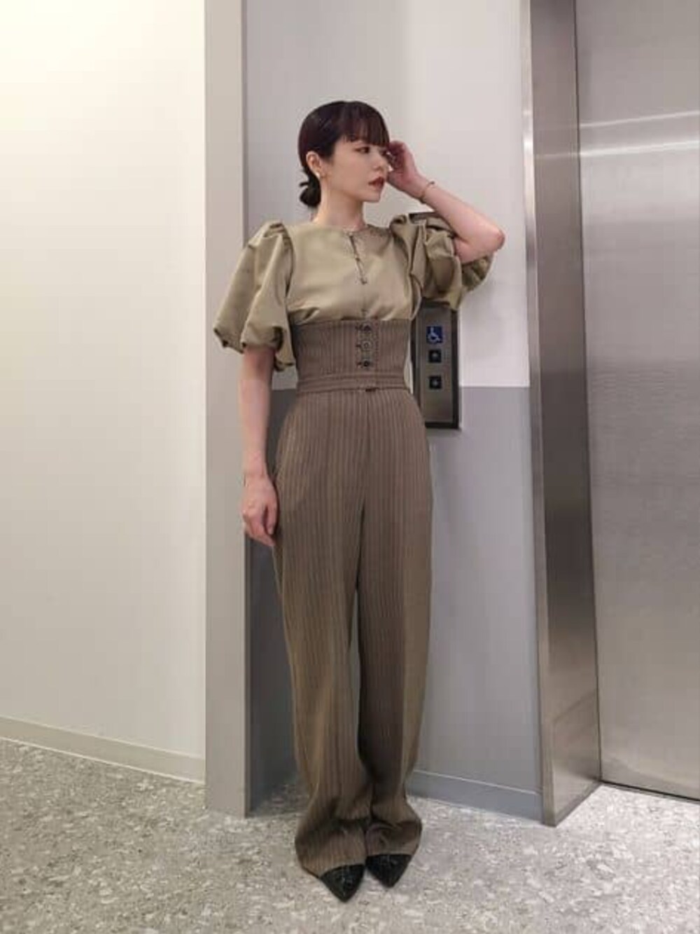 グレー系のその他パンツ、ベージュ系のシャツ/ブラウスを着用したレディースの冬コーディネートの2枚目の写真